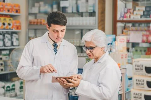 Skilled pharmacist is consulting, analyzing the use of drugs to recommend a.. Stock Photos