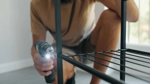 Skilled professional man drilling screwdriver assembling metallic shelf Stock Footage 233470192