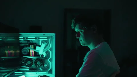 Skilled programmer developing new software illuminated by computer lights in Stock Footage 318469690