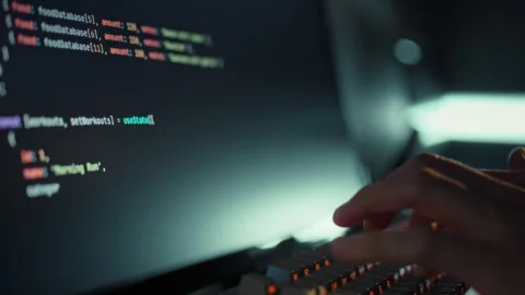 A skilled programmer rapidly enters intricate code on a computer utilizing a Stock-Footage 331456306