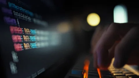 A skilled programmer rapidly types complex code on a keyboard dynamically up Stock Footage 331314892