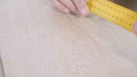 Skilled repairman draws lines between points on wooden board Stock Footage 106376772