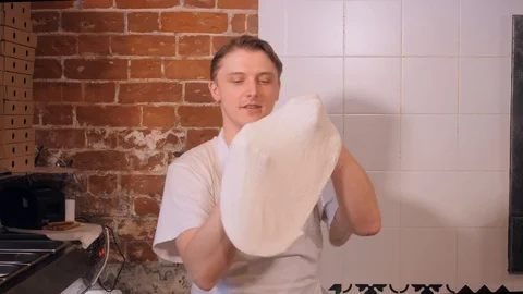 Skilled restaurant employee forms thin dough making pizza Stock Footage 127214942