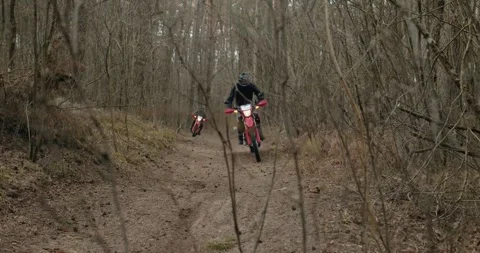 A skilled rider expertly navigates through an offroad motorcycle on a dense Stock Footage 310513209