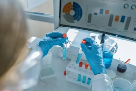 A skilled scientist in a lab conducts complex tests with specialized tubes and Stock Photos