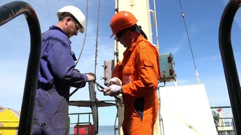 Skilled ship workers hang vessel radar to long rope Stock Footage 113455143