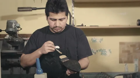 Skilled shoemaker brushing a sole for a boot Stock-Footage 61790196
