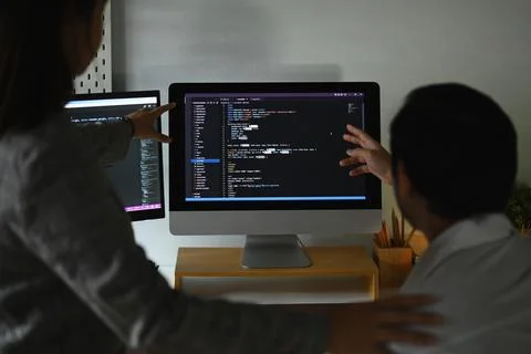 Skilled software developer team programming code on the computer for cyber Foto stock