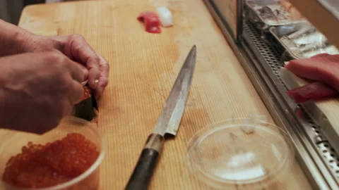 Skilled sushi chef preparing different types of sushi like Tobiko fish roe in sm Stock Footage 199455743