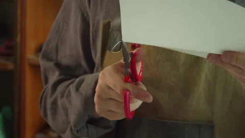 A skilled tailor makes a pattern for making leather goods from a sheet of paper Stock Footage 143721786