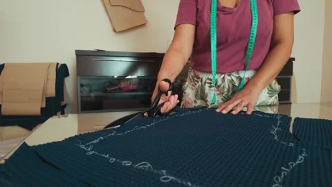 Skilled Tailor's Hands Precisely Cut Patterned Fabric Stock Footage 346410347