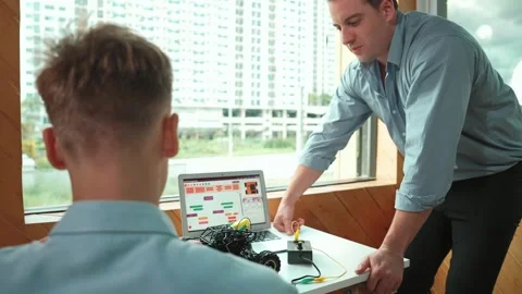Skilled teacher help young student fixing car model at STEM class. Edification Stock Footage 286758561