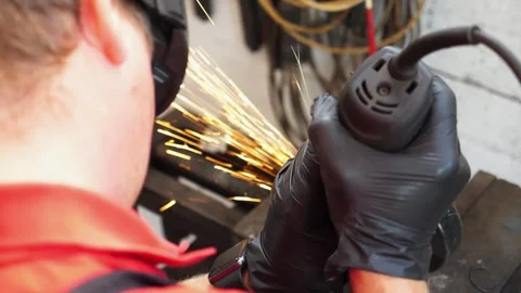 Skilled technician in black gloves operates a power tool, creating sparks Stock Footage 318281553