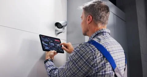 Skilled Technician Ensuring Safe Installation Of CCTV Surveillance System. 写真素材