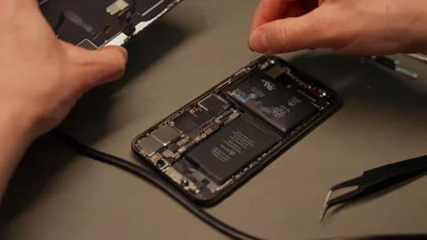 Skilled technician performing smartphone battery replacement, preparation to Stock Footage 306892431