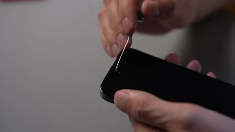 Skilled technician performing smartphone cleaning, removing dust and dirt from Stock Footage 318749396