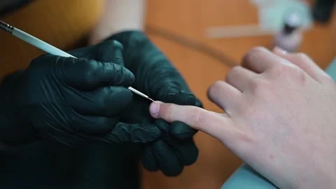 A skilled technician provides nail grooming services to a client. The focus is Video stock 338447260