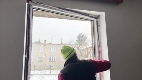 Skilled tradesman installing new window frame in house renovation Stock Footage 327626806