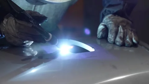 Skilled welder performing TIG welding on curved stainless steel handle 库存影片 334964486