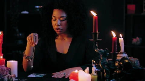 Skilled witch working with pendulum over client's photo, magic ritual, spell Stock Footage 201332338