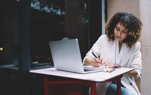 Skilled woman making notes while preparing to university exams Stock Photos
