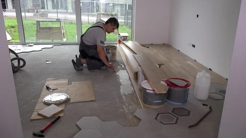 Skilled worker apply glue with trowel on floor for floorboard laying Stock Footage 123104848