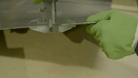 Skilled worker in blue uniform measures metal detail dimensions with calipers Stock Footage 125219245
