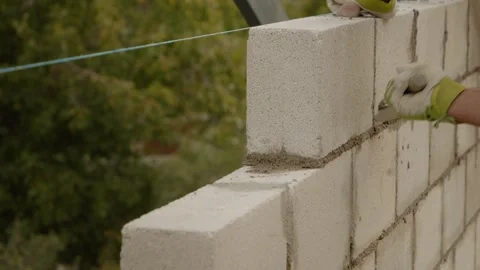 Skilled worker constructs concrete brick wall for new house project Stock Footage 324669601