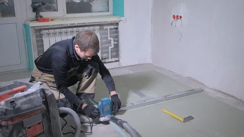 Skilled worker cuts white drywall panel with blue jigsaw Video stock 108582848