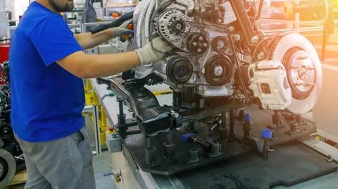 Skilled worker engages in assembling engine parts at an automotive workshop, Stock Photos