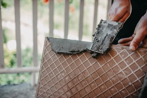 Skilled worker installing the ceramic wood effect tiles on the floor Worker m Stock Photos