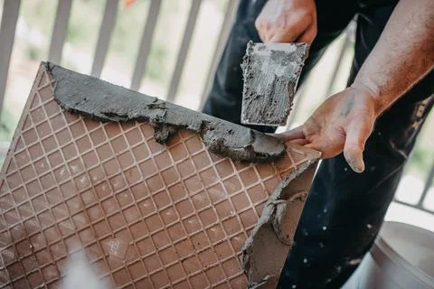 Skilled worker installing the ceramic wood effect tiles on the floor Worker m Stock-Fotos