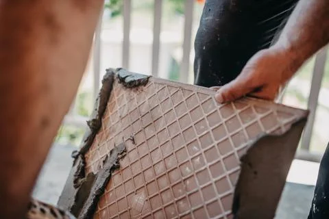 Skilled worker installing the ceramic wood effect tiles on the floor Worker m Stock Photos