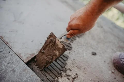 Skilled worker installing the ceramic wood effect tiles on the floor Worker m Stock Photos