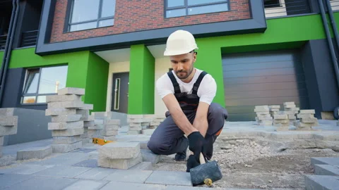 Skilled Worker Laying Paving Stones with Precision Tools Stock Footage 293633713
