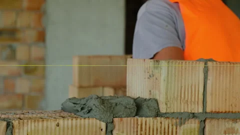 Skilled worker lays bricks spreading mortar at construction site Stock Footage 317605753