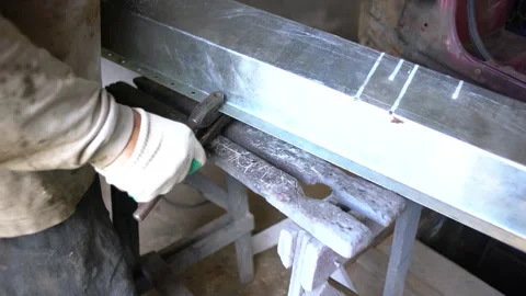 A skilled worker measures and marks metal strips in a workshop setting. Stock Footage 332227154