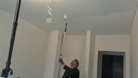 Skilled worker paint ceiling in white color with roller stick tool Stock Footage 108631567