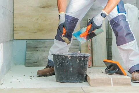Skilled Worker Performing Tile Installation in a Modern Interior Space Photos