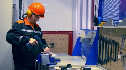 Skilled worker in protective gear operating machinery in workshop. Issues of Stock Footage 278072556