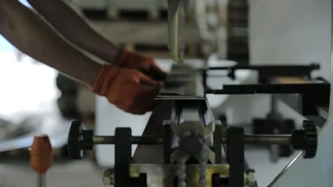Skilled worker puts sheet on automated metal bending machine Stock Footage 138937789