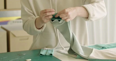 Skilled worker putting the pin to the fabric while preparing future sweatshirt Stock-Footage 200454109