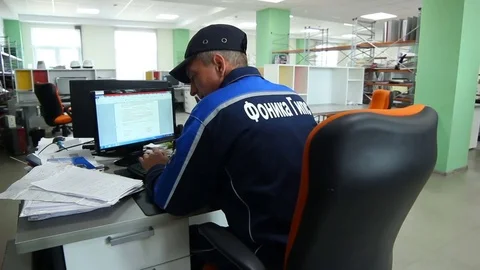 Skilled Worker Sits at Table and Looks at Monitor Stock Footage 77247764