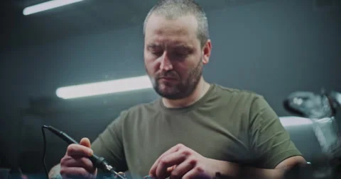 Skilled Worker Soldering Components in Modern Drone Manufacturing Facility Stock Footage 322095338