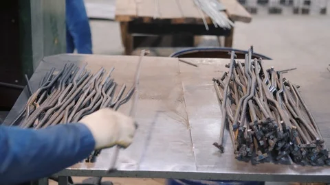 Skilled worker takes rebar element and puts on metal table Video stock 124608168