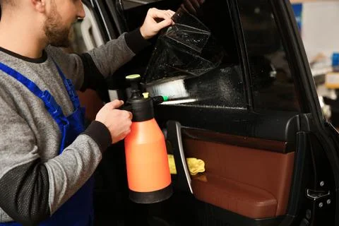 Skilled worker tinting car window in shop Stock Photos
