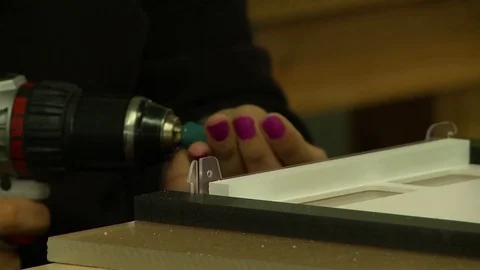 A skilled worker uses a power drill and screws to attach plastic parts in a fact Stock Footage 71042313