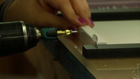 A skilled worker uses a power drill and screws to attach plastic parts in a fact Stock Footage 71042513