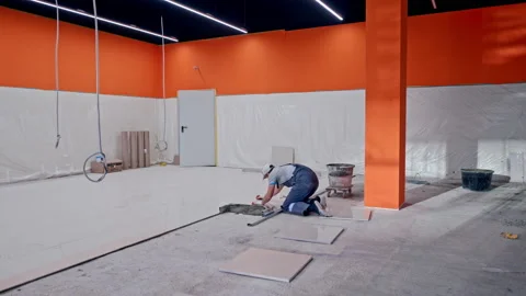 Skilled worker wearing cap prepares floor for tile laying Stock Footage 146680184