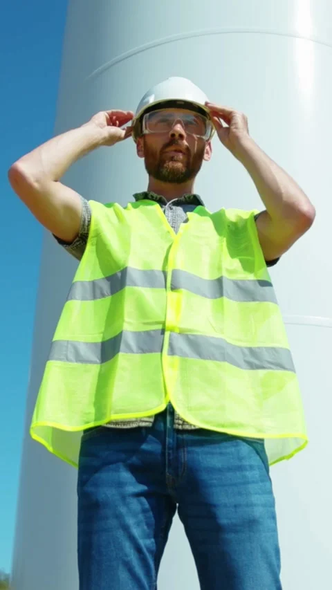 Skilled Worker at a Wind Turbine Site, dedicated to safety and efficiency in Stock Footage 314206540